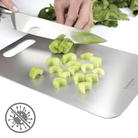 Hands chopping fresh green vegetables on a Vanotium cutting board